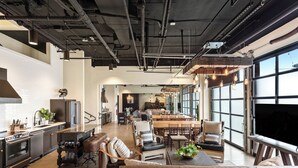 A spacious kitchen with modern appliances, a dining area with a large table and chairs, and a cozy seating area with sofas and a TV. - Inn Cahoots (Austin)