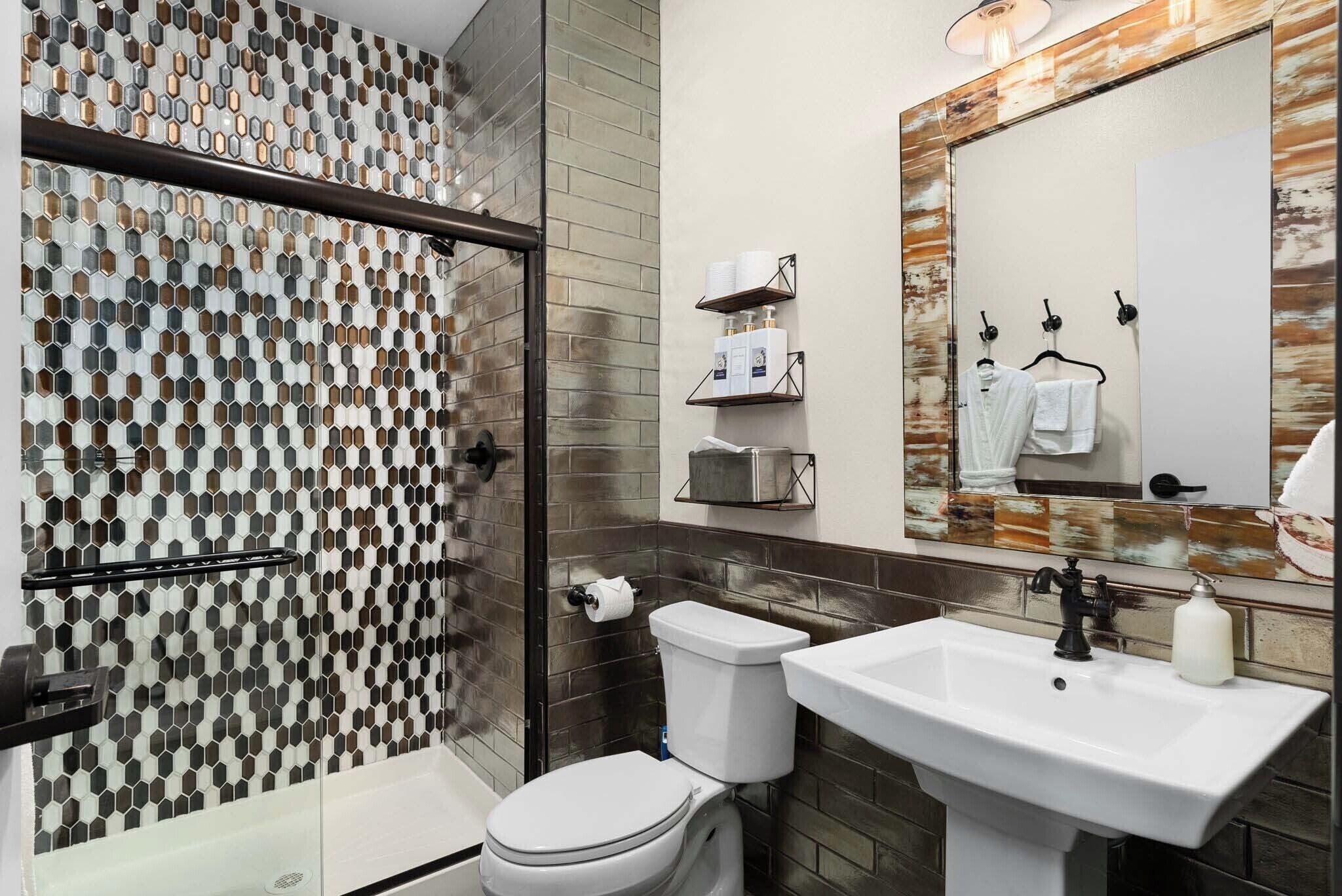 A bathroom with a shower, toilet, and sink.
