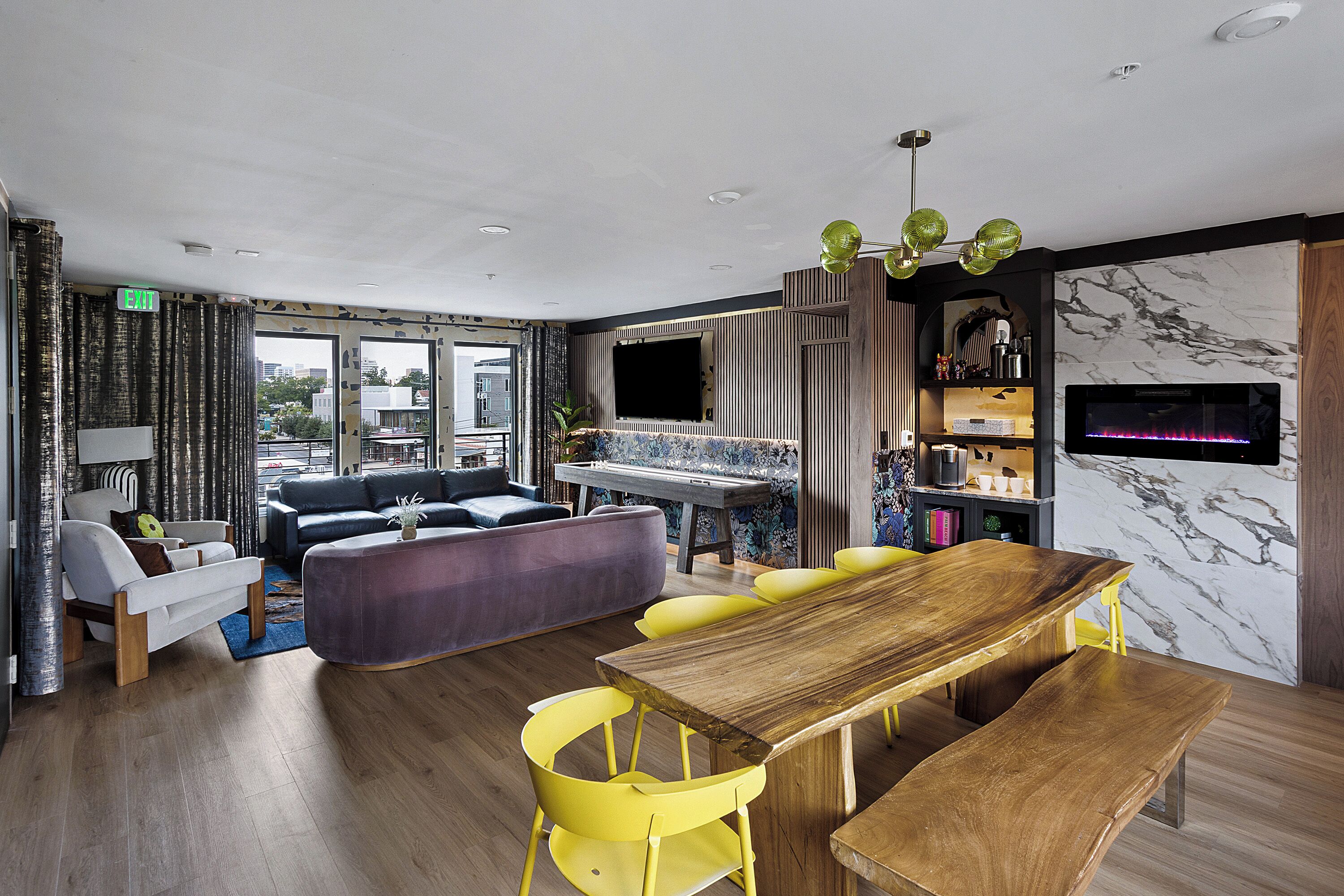 A modern living room with a wooden dining table, yellow chairs, a sofa, and a piano.