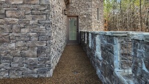 Un bâtiment en pierre avec un chemin de gravier menant à une porte.