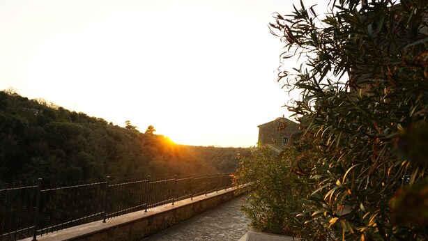 A stone pathway leading to a building with a stone wall and a metal fence. - La Casa Borgo Ischia di Castro (Ischia di Castro)