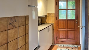 A kitchen with white cabinets, a wooden door with glass panels, and a tiled backsplash. - Lovely home in Haderslev with WiFi (Haderslev)
