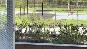 A view of a playground with exercise equipment, surrounded by a fence and trees. - Brand-new studio surrounded by forest, All New Cozy Home in Turku (Turku)