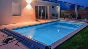 A swimming pool with a tiled deck, a covered patio area, and a screened-in entertainment room. - Gorgeous home in Semussac (Semussac)