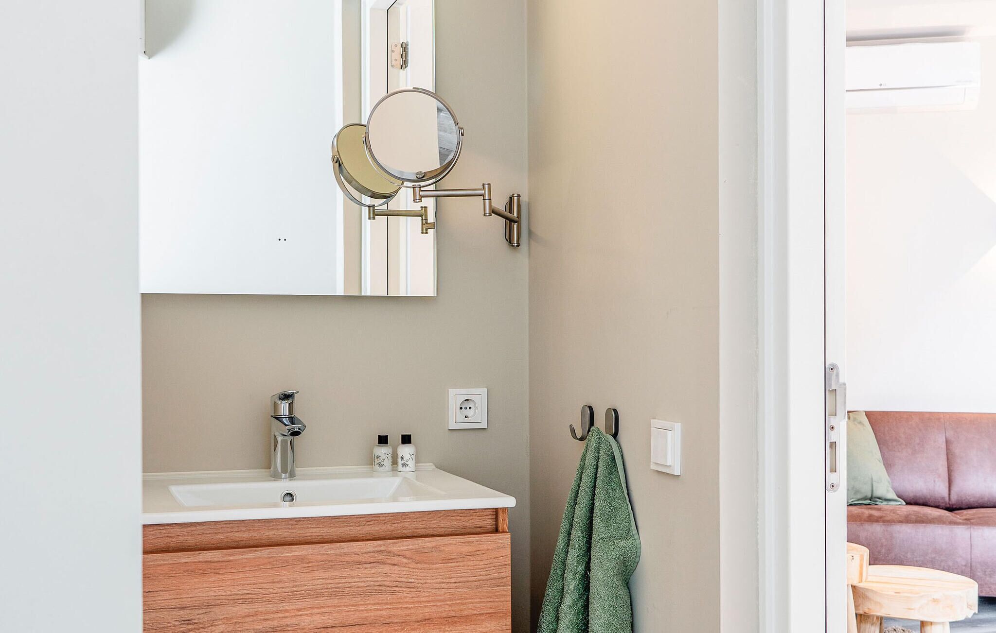 Une salle de bain équipée d’un lavabo, d’un miroir et d’un porte-serviettes.