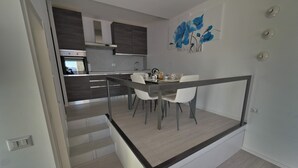 A modern kitchen with a dining area, featuring a staircase leading to another level. - Eco-friendly design, modern comforts and a prime scenic location (Someraro)