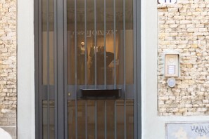 A door with vertical bars, a small mailbox, and a stone wall.