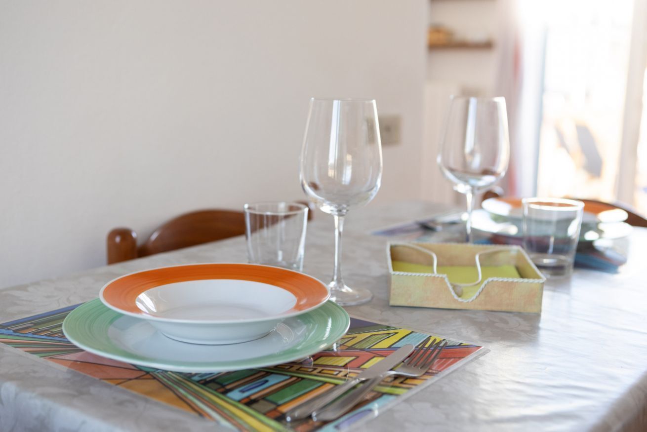 Een eettafel met borden, glazen en een servet houder.