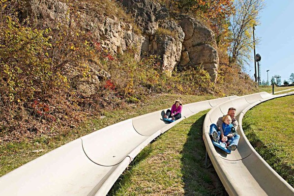Une personne qui descend un toboggan en béton dans un parc.
