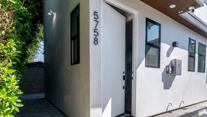 A building entrance with a door marked '5758,' a small window, and a security camera.