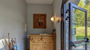 A modern kitchen with wooden cabinets, a built-in stove, and a large glass door leading to an outdoor area.