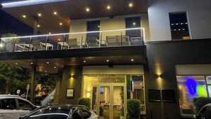 A modern building with a flat roof, a covered outdoor seating area, and a visible entrance. - Historic Uptown 2BD w/Shared Patio Pet-friendly (St. Petersburg)