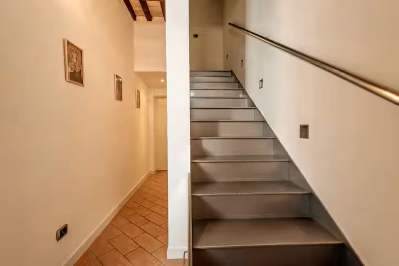 A staircase with a handrail, leading to an upper floor.