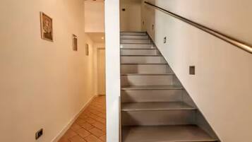 A staircase with a handrail, leading to an upper floor.