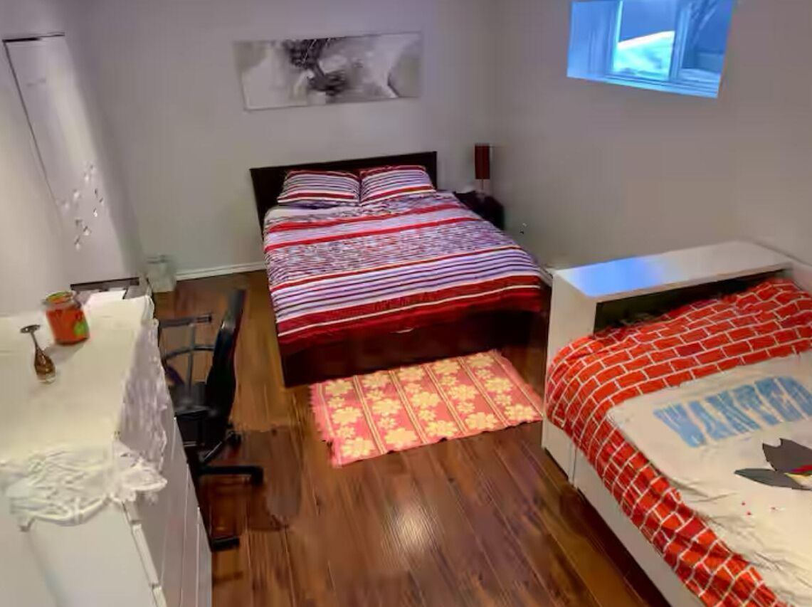 Une chambre à coucher avec un lit, un bureau, une chaise et une fenêtre.