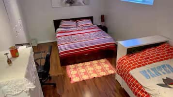 Une chambre à coucher avec un lit, un bureau, une chaise et une fenêtre.