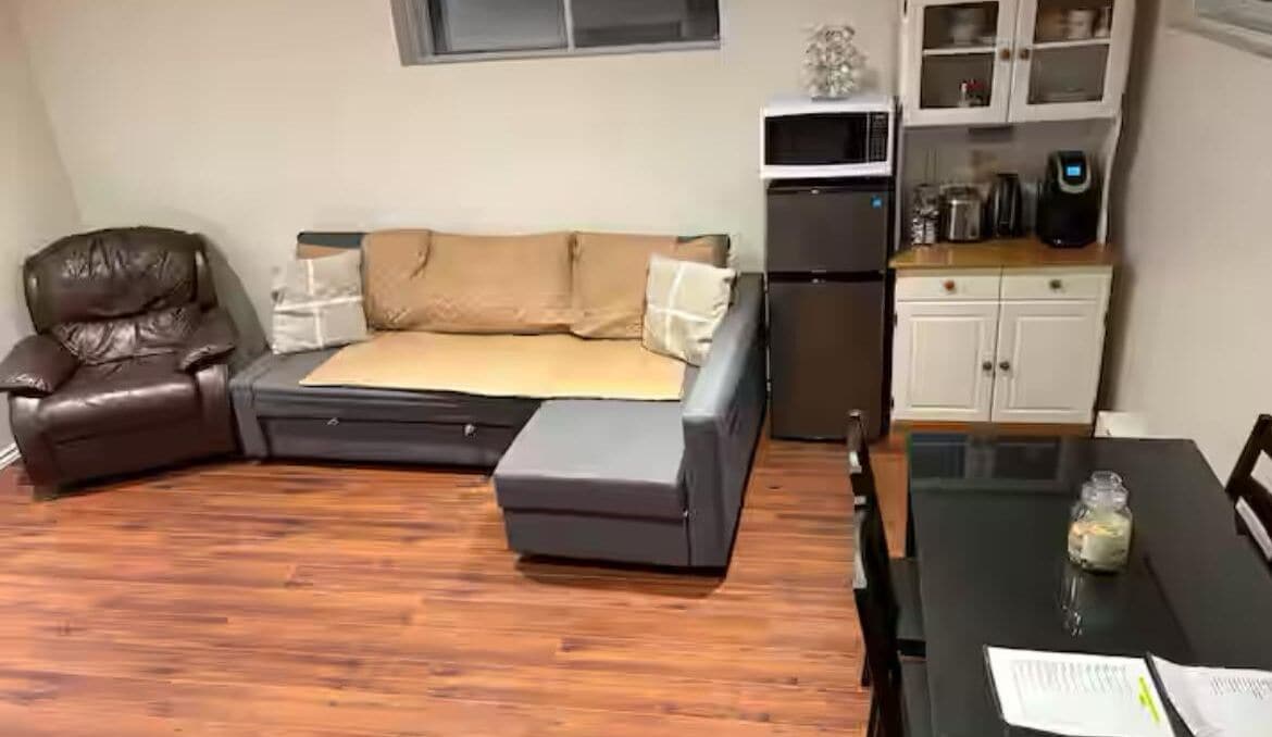 A compact living space with a sofa, a dining table, and a kitchen area.