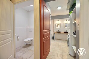 Un baño con inodoro, lavamanos y lavadora.