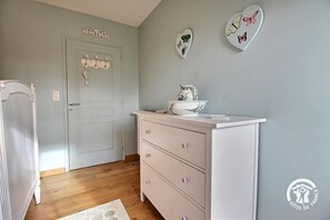 Une pièce avec une porte blanche, une commode à tiroirs et des assiettes décoratives représentant des papillons accrochées au mur.