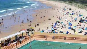 A beach with a swimming pool and beach umbrellas. - Entire spectacular lake and ocean view holiday house (Lake Heights)
