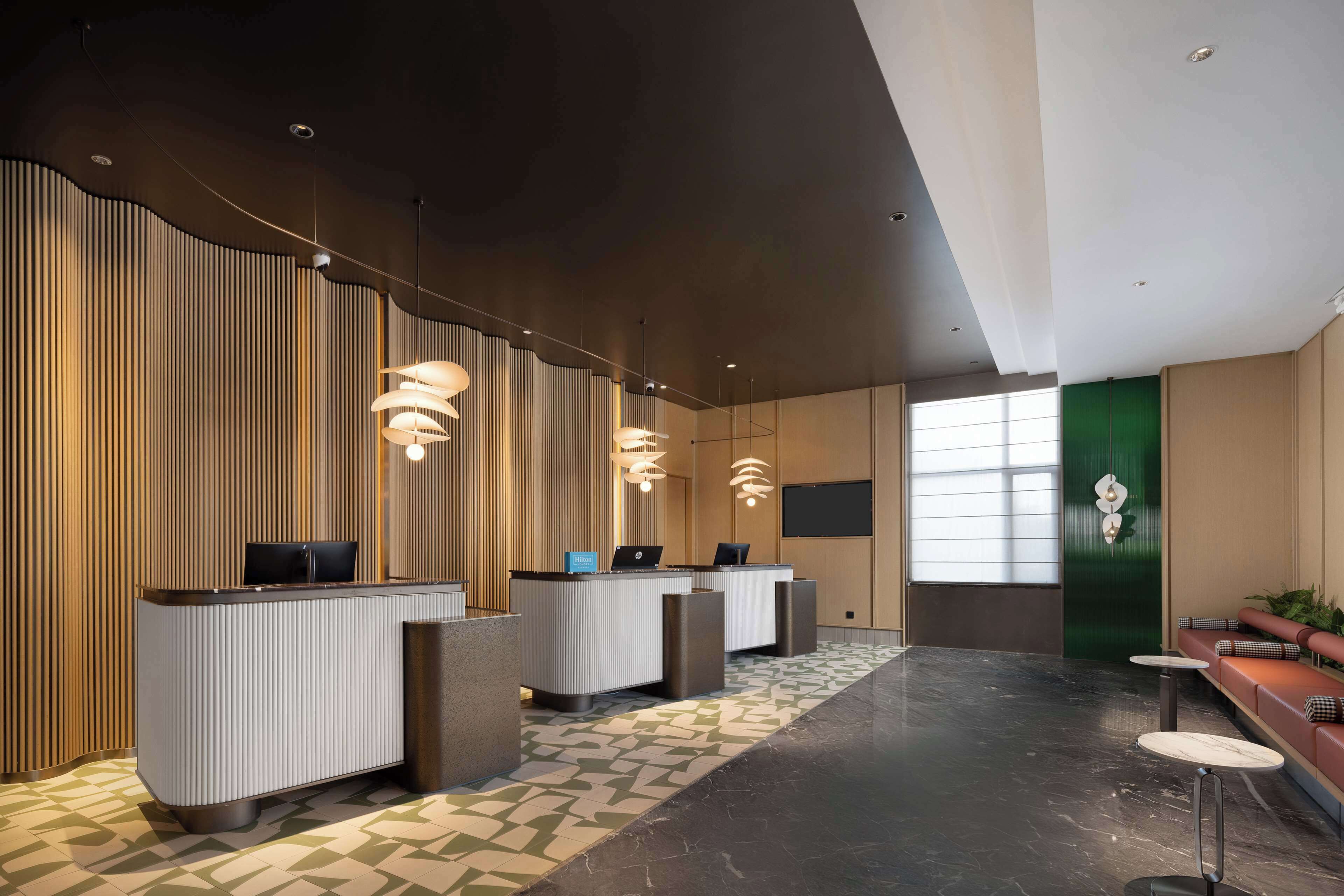 A modern reception area with a reception desk, seating area, and decorative lighting.