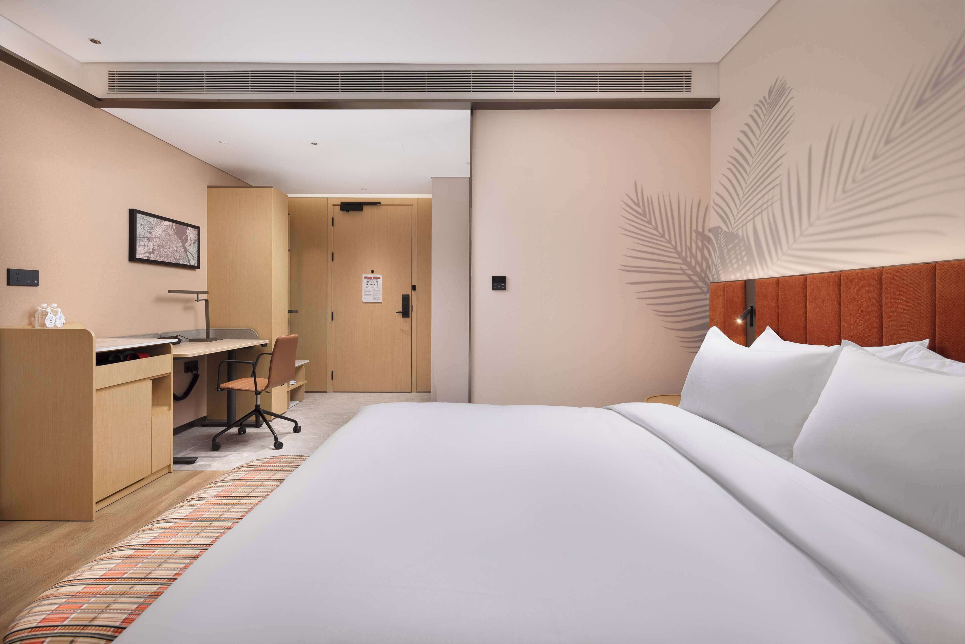 Una habitación de hotel con una cama, un escritorio y una silla.