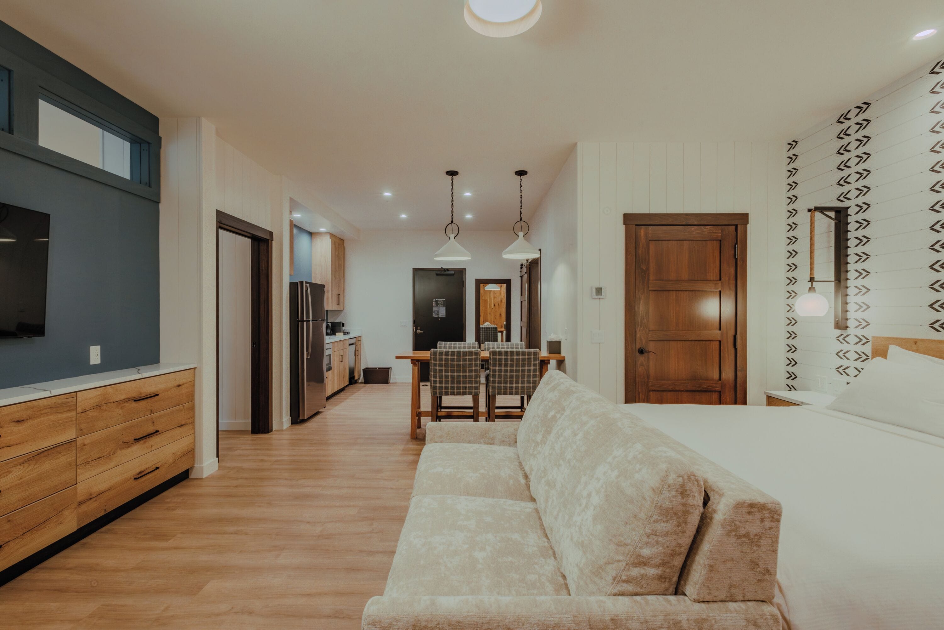 A modern interior with a sofa, dining area, and kitchen.