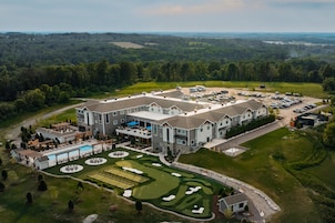 A large hotel with multiple buildings, a swimming pool, and a golf course.