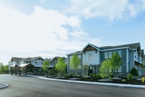 A residential area with modern houses, a covered walkway, and a well-maintained lawn. - Skaneateles Fields Resort & Spa, Curio Collection By Hilton (Skaneateles)