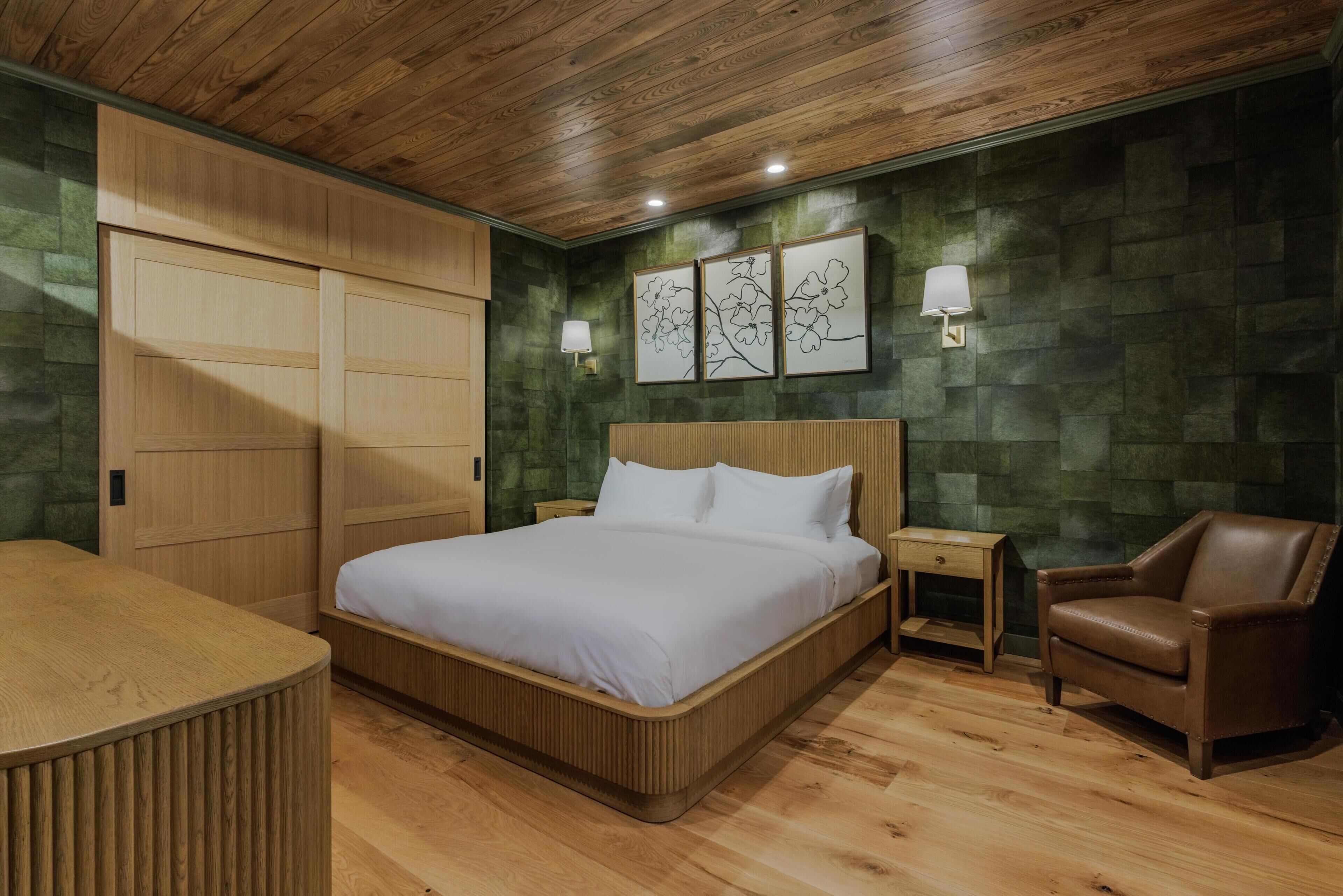 A bedroom with a wooden bed, a nightstand, a chair, and a wardrobe.