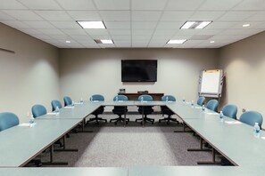 A conference room with a long table, chairs, a flat-screen TV, a whiteboard, and a projector. - Skaneateles Fields Resort & Spa, Curio Collection By Hilton (Skaneateles)