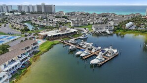 A marina with docked boats, a pool, and a building with a covered patio.