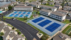 A residential area with multiple two-story buildings, a tennis court, and a parking lot.
