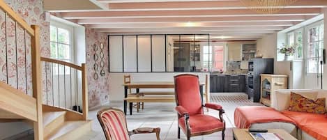 Una sala de estar moderna con sillas a rayas, un sofá rojo y una mesa de centro de madera.