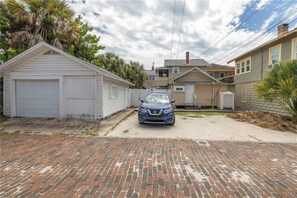 Il s'agit d'une propriété résidentielle dotée d'une allée pavée en briques, d'un garage et d'une maison à deux étages avec un grenier apparent.