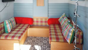 A room with a sofa set, a television mounted on the wall, and a lamp. - 1 bedroom accommodation in Ormskirk (Ormskirk)