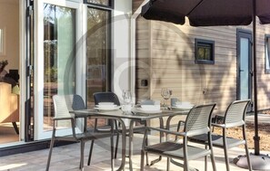 Enjoy dining al fresco on the patio, adjacent to a spacious living area with a sliding glass door.