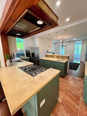 A modern kitchen with a central island, stainless steel appliances, and a view to the outdoors. - US Open Stay - Hudson River View Estate with Private Tennis Court (Nyack)