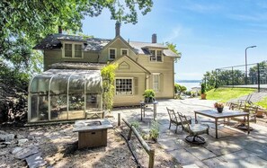 A house with a greenhouse, patio furniture, and a view of the water. - US Open Stay - Hudson River View Estate with Private Tennis Court (Nyack)