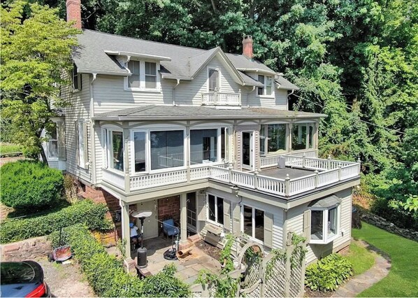 A two-story house with a large balcony, a covered porch, and a garage. - US Open Stay - Hudson River View Estate with Private Tennis Court (Nyack)
