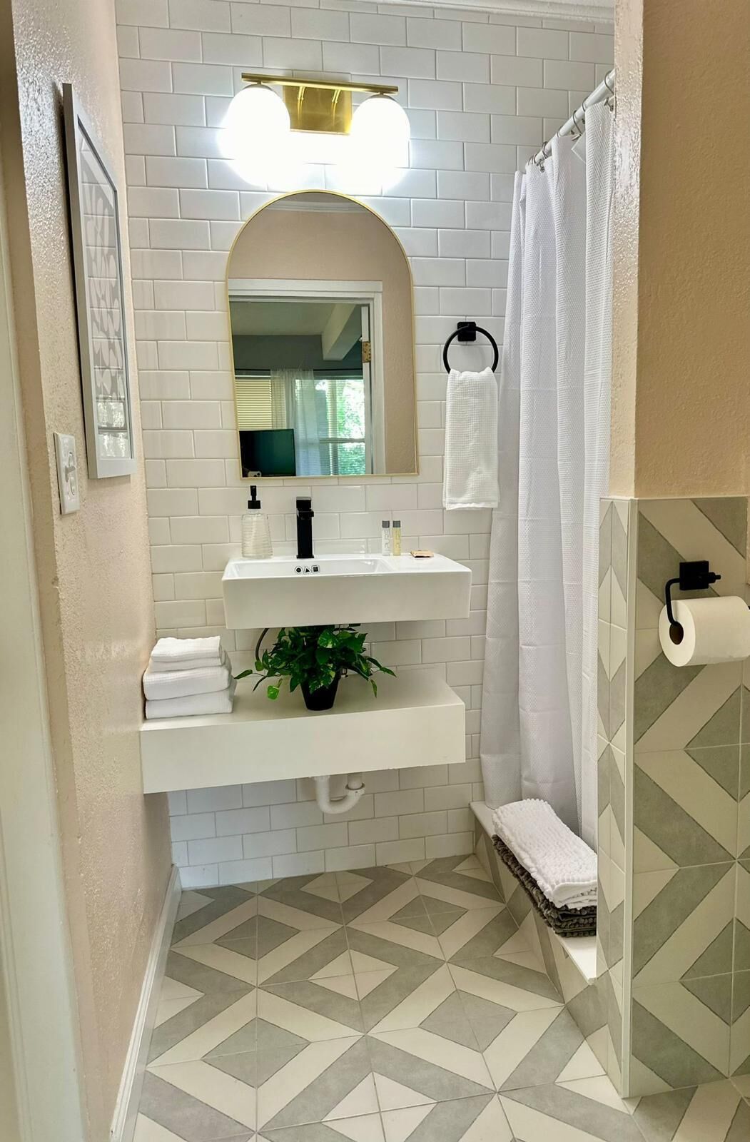 A bathroom with a white sink, mirror, and shower curtain.