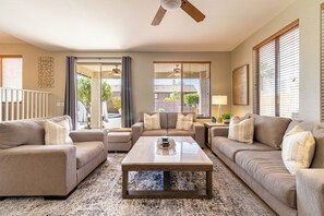 A living room with a sofa set, a coffee table, and a ceiling fan. - Desert Oasis: 4BD/3BA- Pool/ 2 Living Rooms / Sleeps 8 (Mesa)
