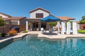 A residential property with a swimming pool, patio furniture, and a covered outdoor seating area. - Desert Oasis: 4BD/3BA- Pool/ 2 Living Rooms / Sleeps 8 (Mesa)