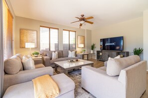 A modern living room with a sofa set, a coffee table, and a television. - Desert Oasis: 4BD/3BA- Pool/ 2 Living Rooms / Sleeps 8 (Mesa)
