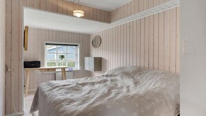 A bedroom with a bed, a desk with a computer, a window, and a mirror. - Cozy home in Juelsminde with WiFi (Juelsminde)