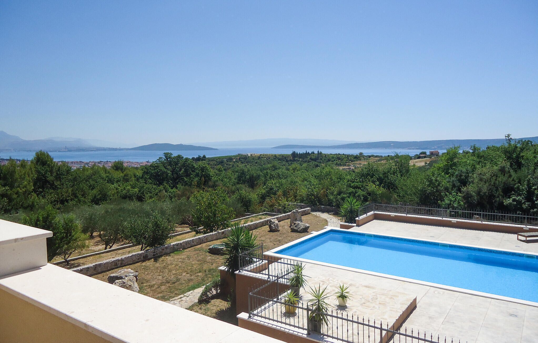 Un espace piscine offrant une vue dégagée sur la mer et les montagnes lointaines.