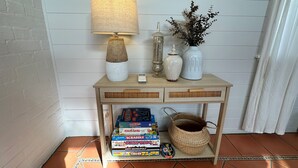 Ein Konsolentisch aus Holz mit Lampe, Vasen und einem Korb.