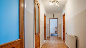 A hallway with wooden doors, a radiator, and a chandelier.