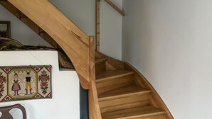 Een houten trap met een leuning, die leidt naar een verdieping.
