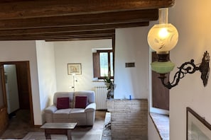 Un salon chaleureux avec un canapé, une table, une lampe et une cheminée.
